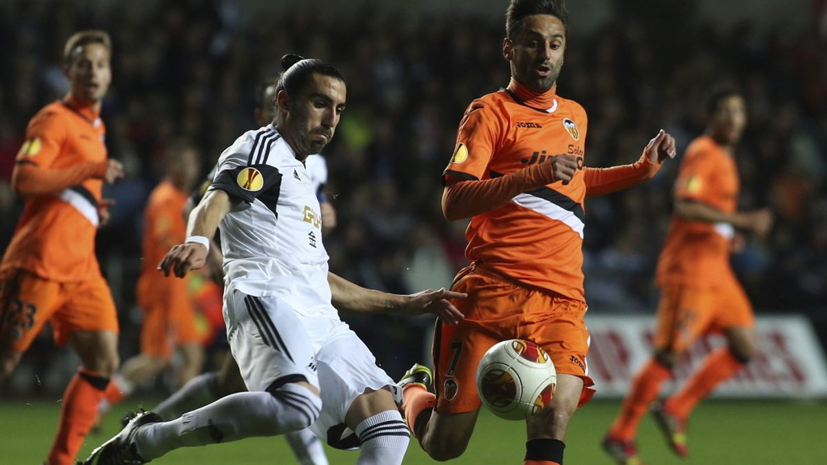 El jugador del Swansea Chico Flores pelea por el control del balón con el delantero brasileño del Valencia, Jonás