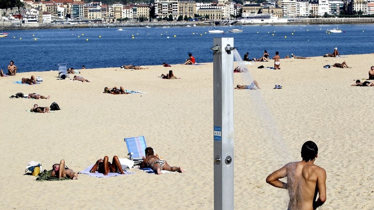Numerosas personas disfrutan hoy en la playa de Ondarreta de San Sebastián, donde a pesar de estar ya en otoño se registran temperaturas veraniegas.