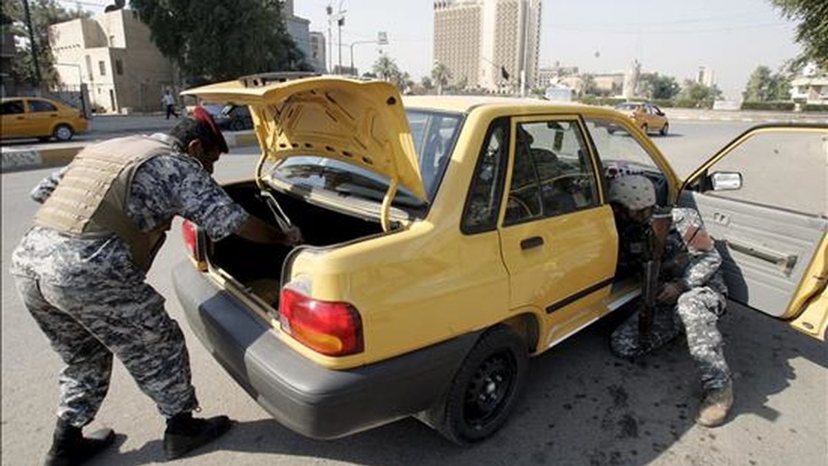 Policias iraquíes inspeccionan un coche en un puesto de control en el centro de Bagdad. EFE/Archivo