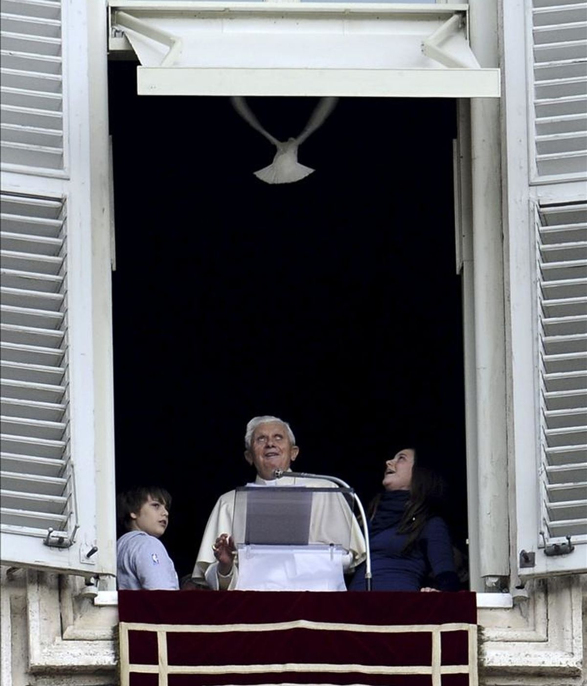 El papa Benedicto XVI (c) y dos niños de la organización "Azione Cattolica" echan a volar una palona durante el tradicional rezo del Ángelus dominical en la plaza de San Pedro, en el Vaticano. EFE