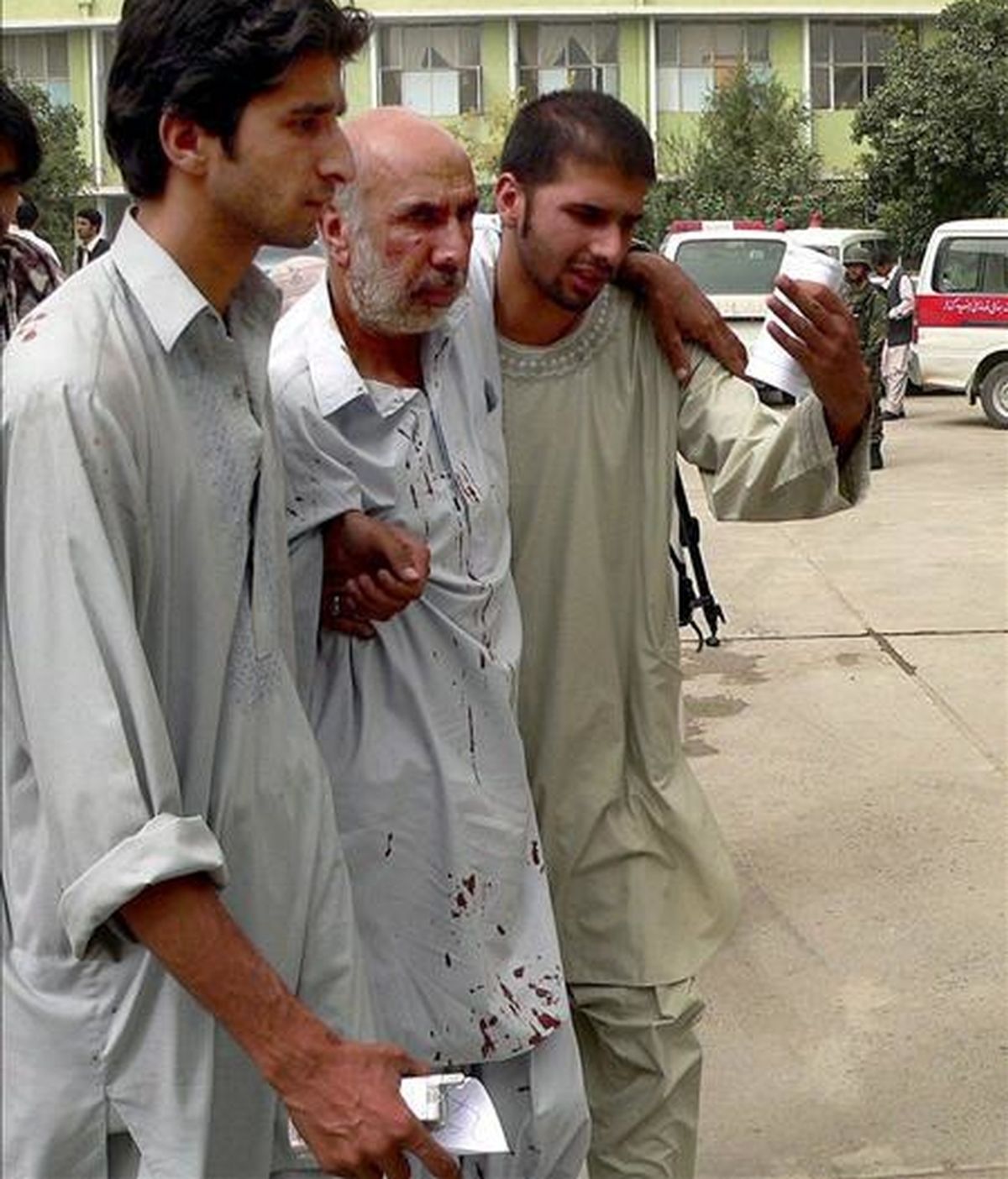 Dos jóvenes ayudan a un herido después de un doble ataque suicida contra una comisaría de la sureña ciudad de Kandahar (Afganistán). EFE/Archivo