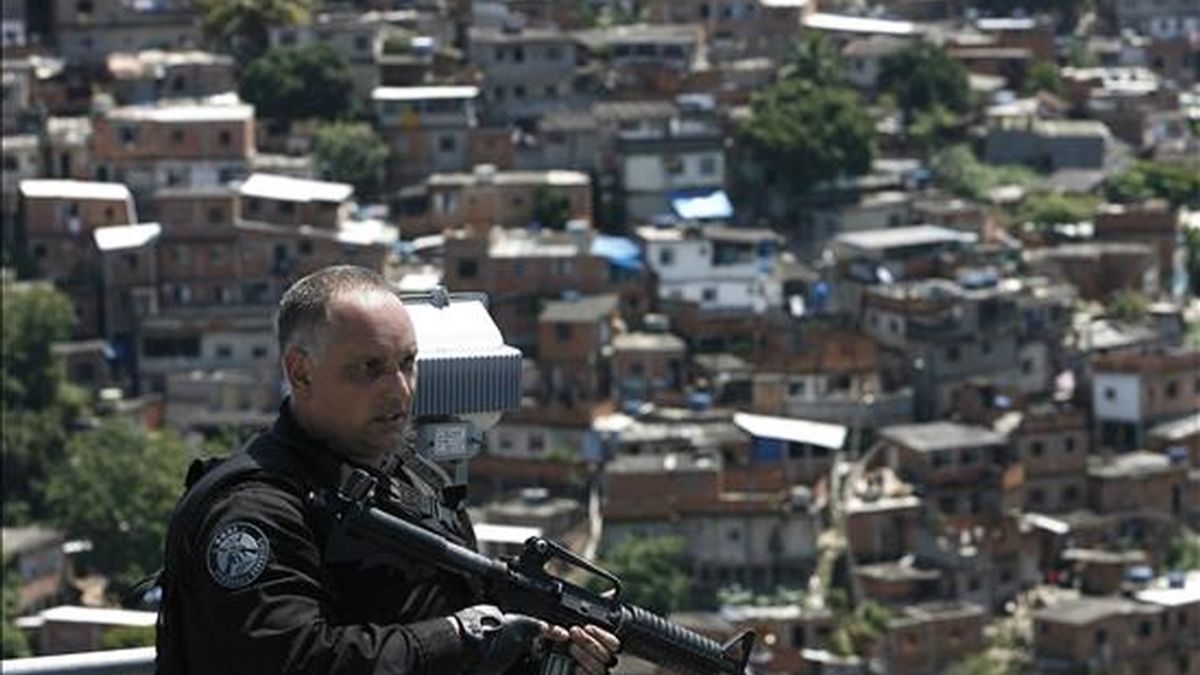 Un policía monta guardia en el Complexo do Alemao donde las fuerzas de seguridad izaron la bandera de Brasil para simbolizar la toma de ese conjunto de favelas en Río de Janeiro (Brasil) que hasta esta mañana era dominado por narcotraficantes. EFE