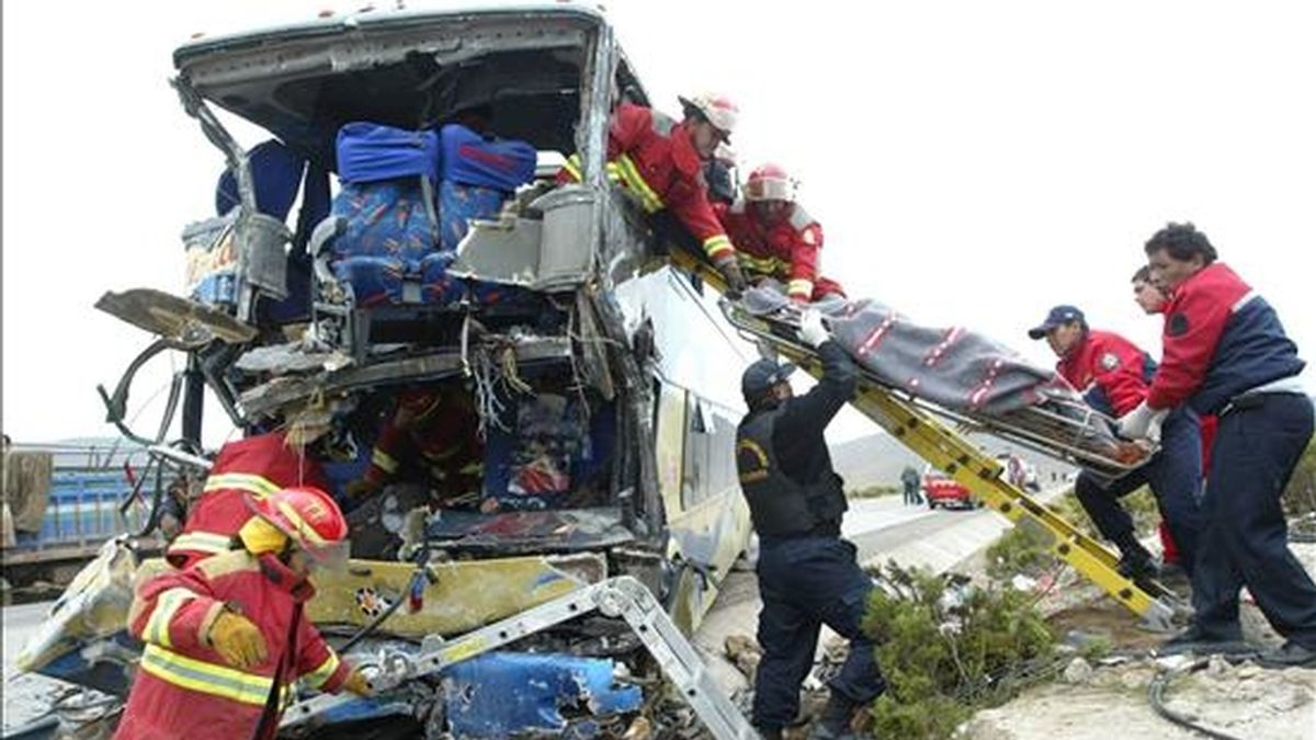Miembros del Cuerpo de Bomberos y de la Policía Nacional de Perú extraen un cadáver del interior de un bus destrozado hoy en el departamento de Arequipa (Perú). EFE