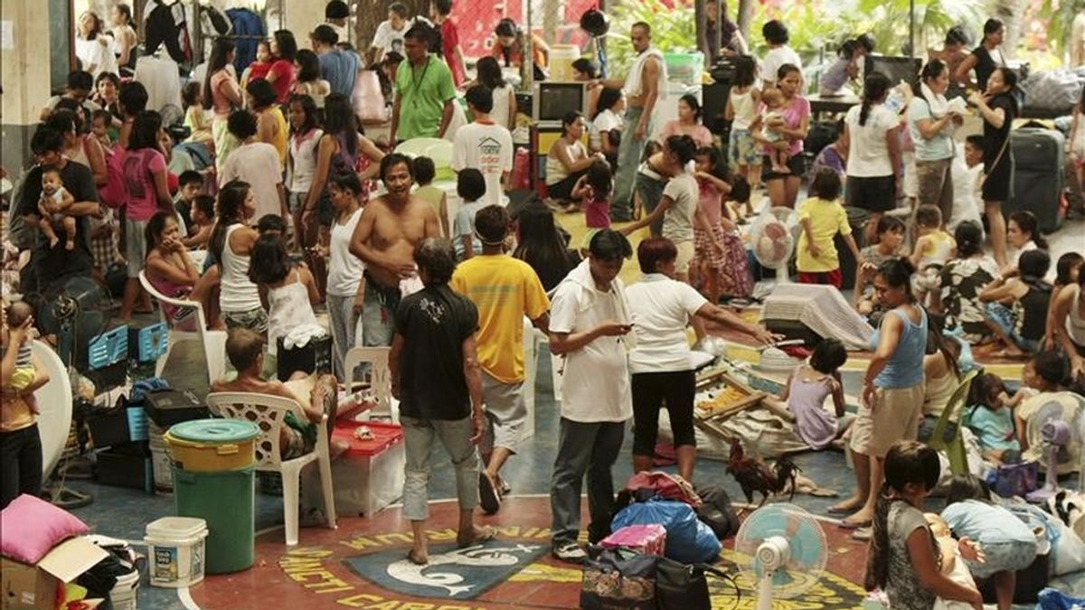 Varias personas permanecen en un centro de evacuación, luego que un enorme incendio arrasara al menos 700 chabolas de un barrio de Makati, al sur de Manila (Filipinas), hoy, 19 de abril de 2011. EFE