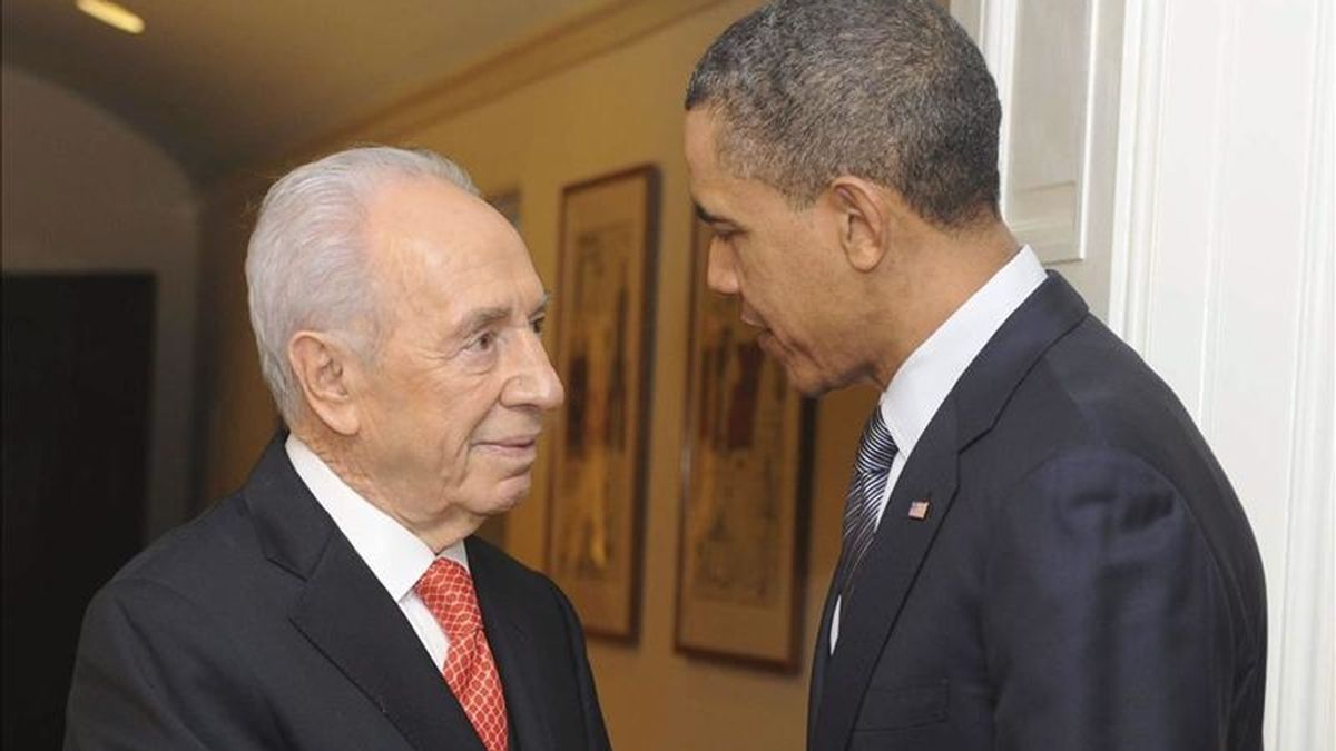El presidente de los Estados Unidos, Barack Obama, (d), estrecha la mano del presidente israelí Shimon Peres (i) durante el encuentro que han mantenido en la Casa Blanca, Washington, Estados Unidos. EFE