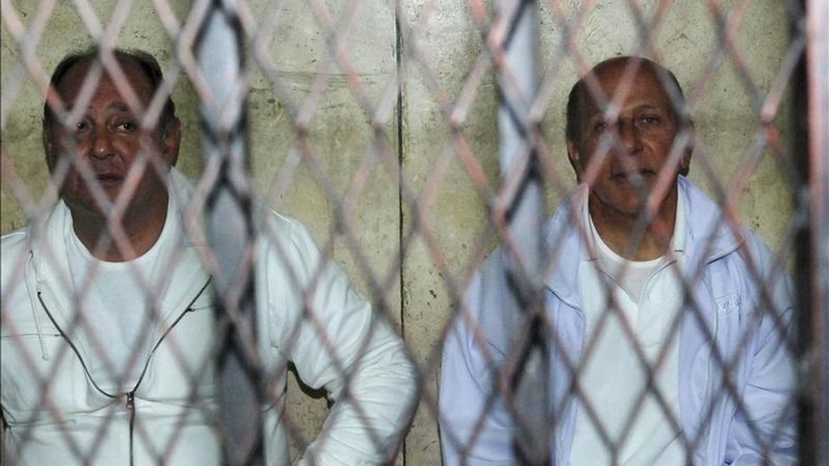 Los ex ministros egipcios de Vivienda, Ahmed el Maghrabi (d) y Turismo, Zuhair Garana (i), son fotografiados tras las rejas en una corte de El Cairo, Egipto, el pasado 23 de febrero. EFE/Archivo