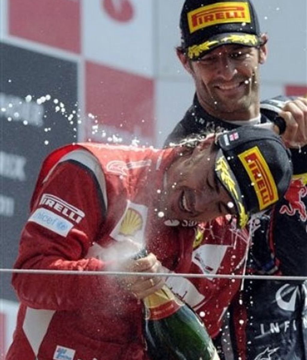 Webber 'ducha' con champán a Fernando Alonso. Foto: AP.