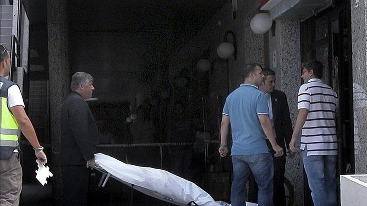 Operarios de los servicios funerarios retiran el cuerpo de una mujer que ha muerto hoy decapitada en un establecimiento de la avenida Juan Carlos I de Arona, en el sur de Tenerife. EFE