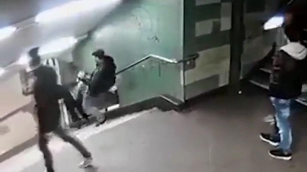 Un hombre tira de una patada en la espalda a una mujer por las escaleras del metro
