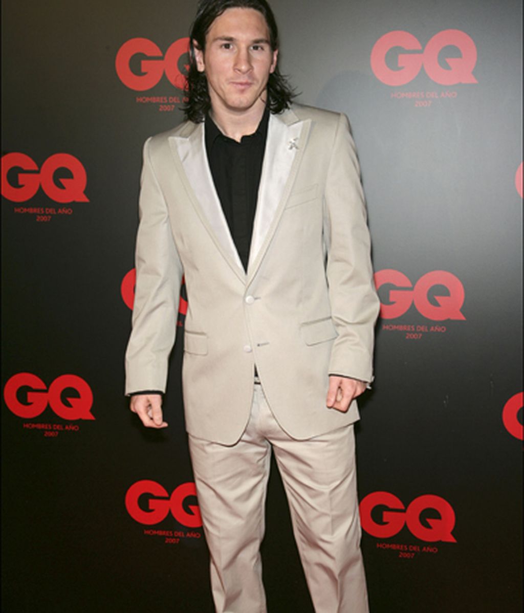 Muy elegante, con un traje beis