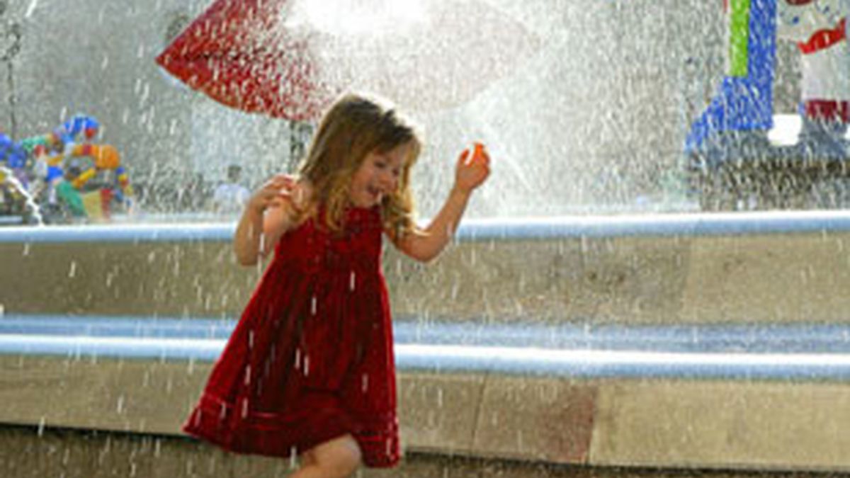 Una niña se refresca en una fuente. Fotos: EFE