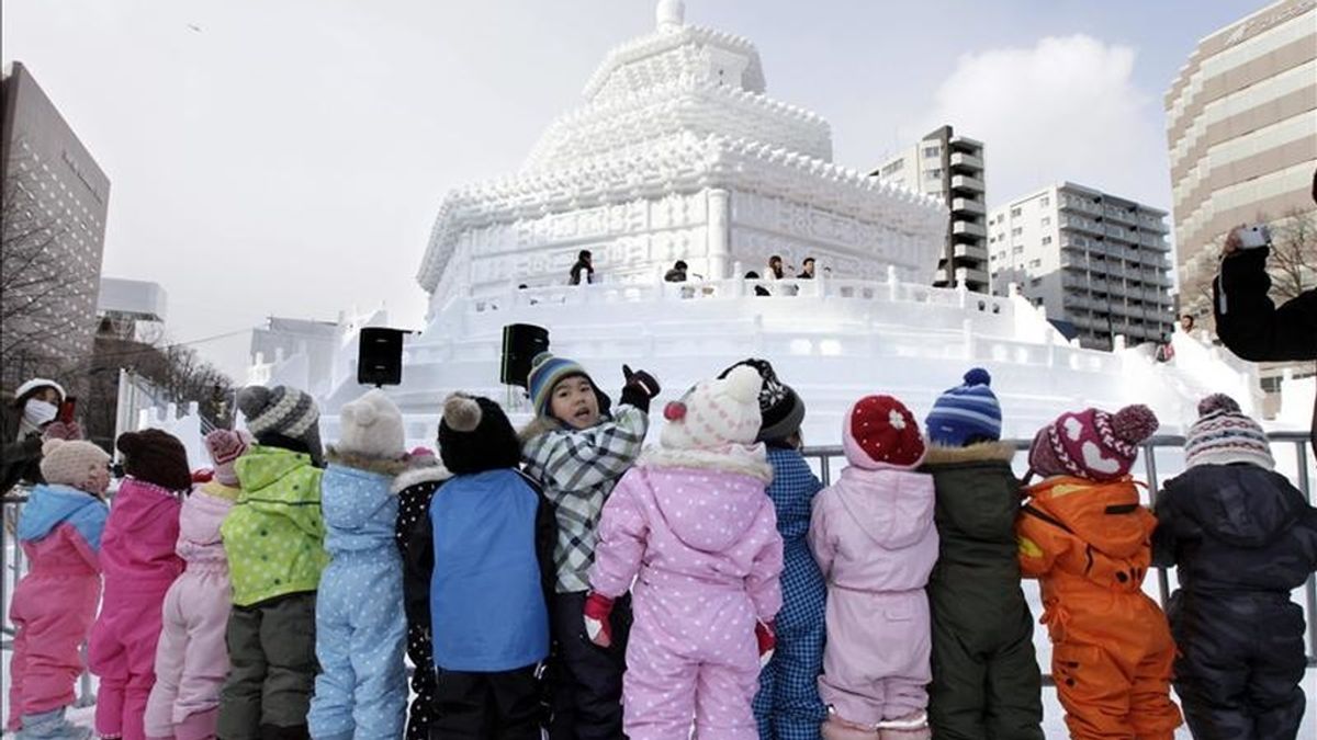 Niños observan una escutura de hielo del Templo del Cielo de Pekín, hoy el Festival de la Nieve de Sapporo en Odori Park Avenue en Sapporo, norte de Japón. EFE