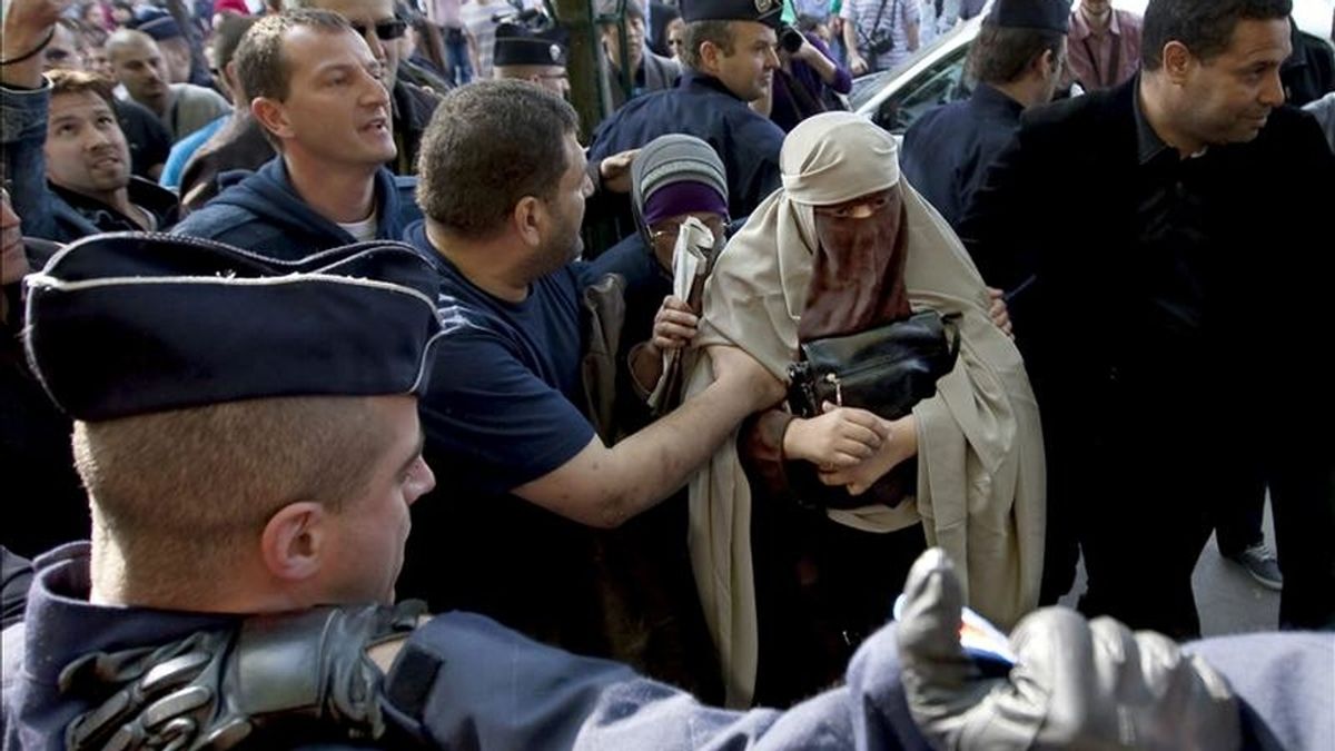 Kenza Drider (c), con niqab, es detenida por la policía francesa tras atender a los medios delante de la catedral de Notre Dame, en París, Francia. EFE