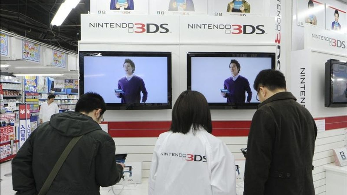 Un par de clientes prueban la nueva videoconsola portátil Nintendo 3DS en una tienda de electrónica del centro de Tokio (Japón). EFE/Archivo