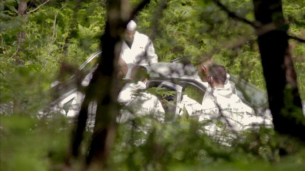 Investigadores de la Guardia Civil, analizan el vehículo donde el cuerpo de Miguel Hervella Vilariño, presunto asesino por apuñalamiento de la joven Gloria García, de 19 años, ha sido localizado, esta mañana en una pista forestal próxima al polígono de A Picaraña, en el municipio coruñés de Padrón. EFE