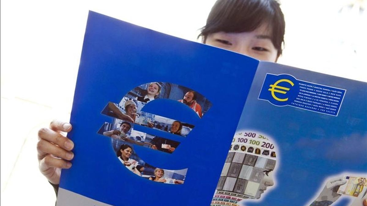 Una mujer lee un folleto sobre el euro cerca de la oficina del Banco Central Europeo (BCE). EFE/Archivo