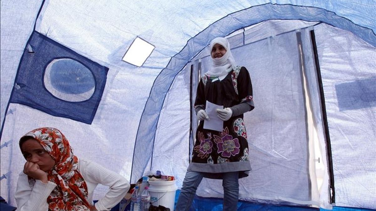 Una mujer libia y su familia, que huyen de la violencia producida cerca a la ciudad occidental libia de Nalut, habla dentro de una tienda de campaña en un campamento de refugiados abierto por parte de la organización Luna Roja en Ramada, a unos 25 km de la frontera sur de Libia, en Dehiba (Túnez). EFE/Archivo