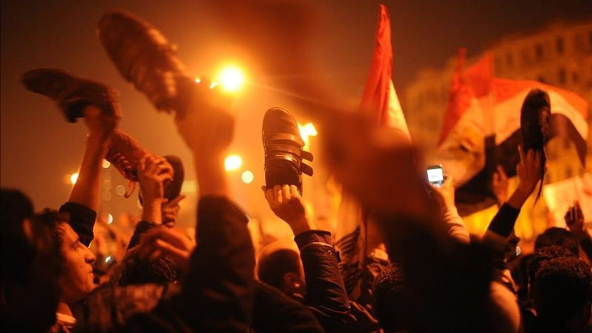 Ciudadanos levantan sus zapatos para protestar contra la negativa del presidente Hosny Mubarak de renunciar antes del mes de septiembre en la Plaza de Tahrir, en El Cairo. EFE