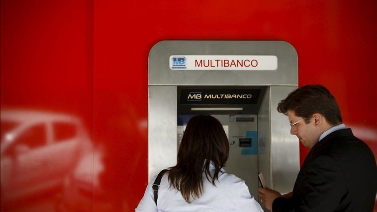 Una pareja saca dinero de un cajero automático, en Lisboa, Portugal. EFE/Archivo