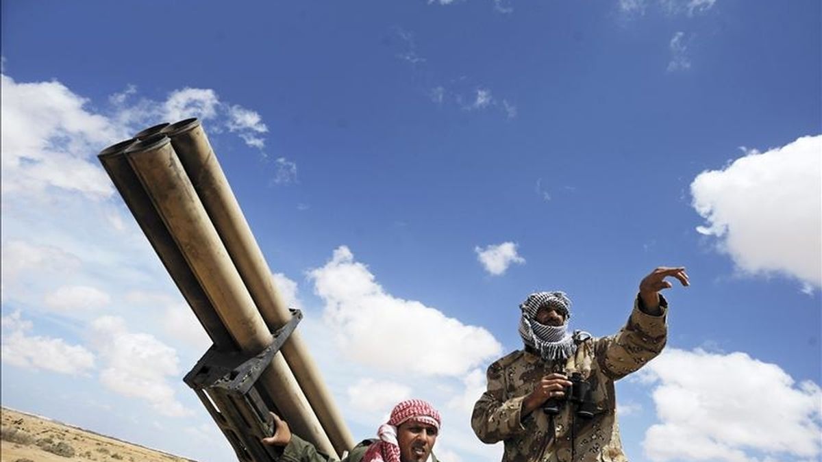 Soldados rebeldes libios conversan detrás de un lanzamisiles en un punto de control en la localidad de Ajdabiya, Libia. EFE