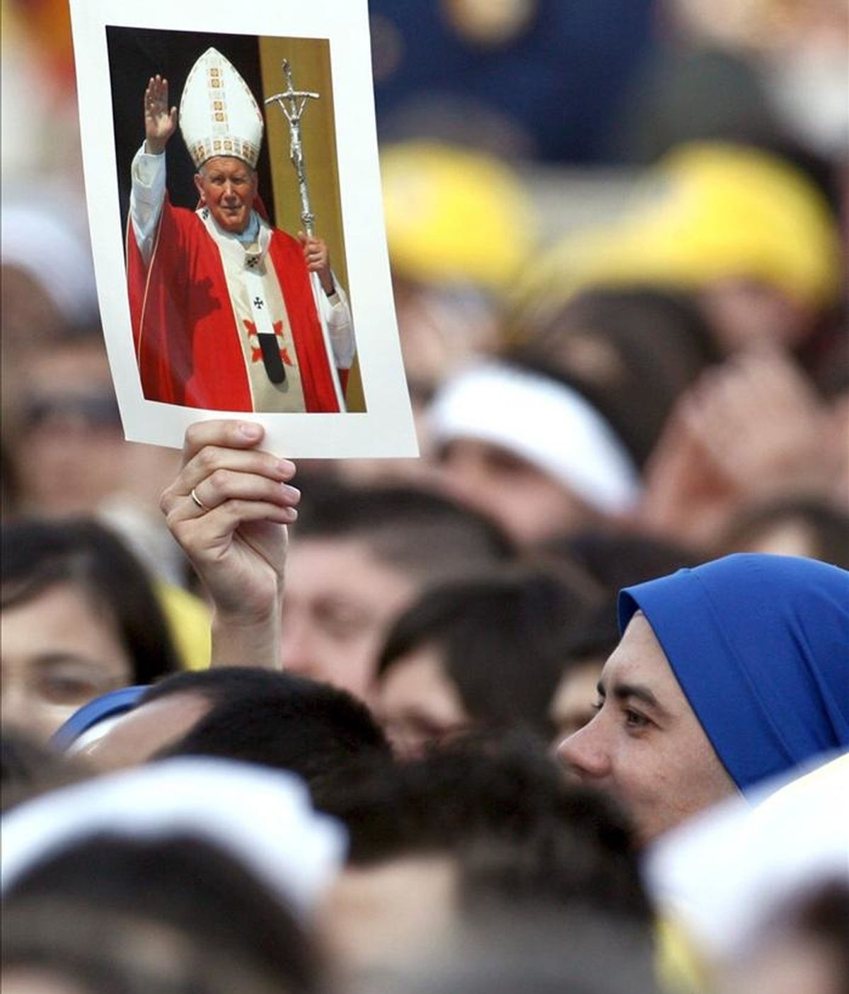 Un fiel alza la foto del difunto papa Juan Pablo II durante el encuentro del papa Benedicto XVI con los jóvenes celebrado en abril de 2006, en la plaza de San Pedro. EFE/Archivo