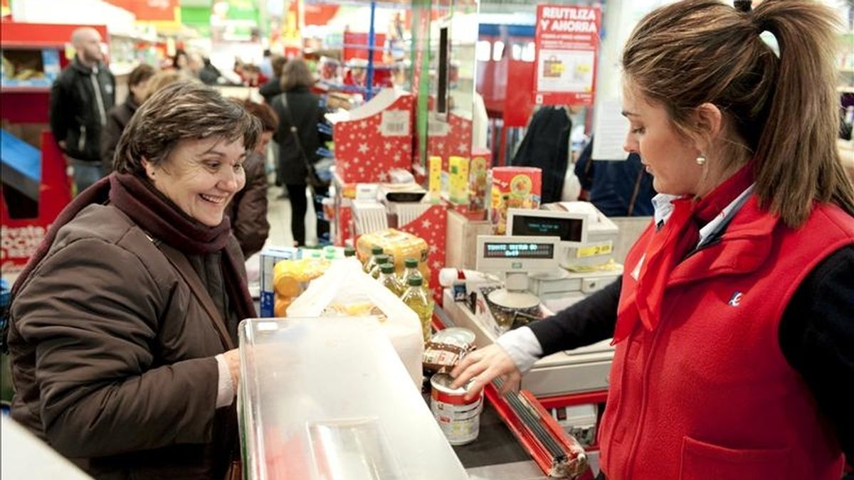En la imagen, una cajera atiende a una clienta en un supermercado. EFE/Archivo