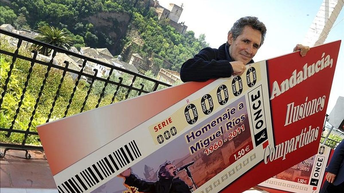 El cantante granadino Miguel Ríos, enseña el cartel del cupón de la ONCE, que el próximo 3 de mayo se dedicará a su despedida de los escenarios. EFE