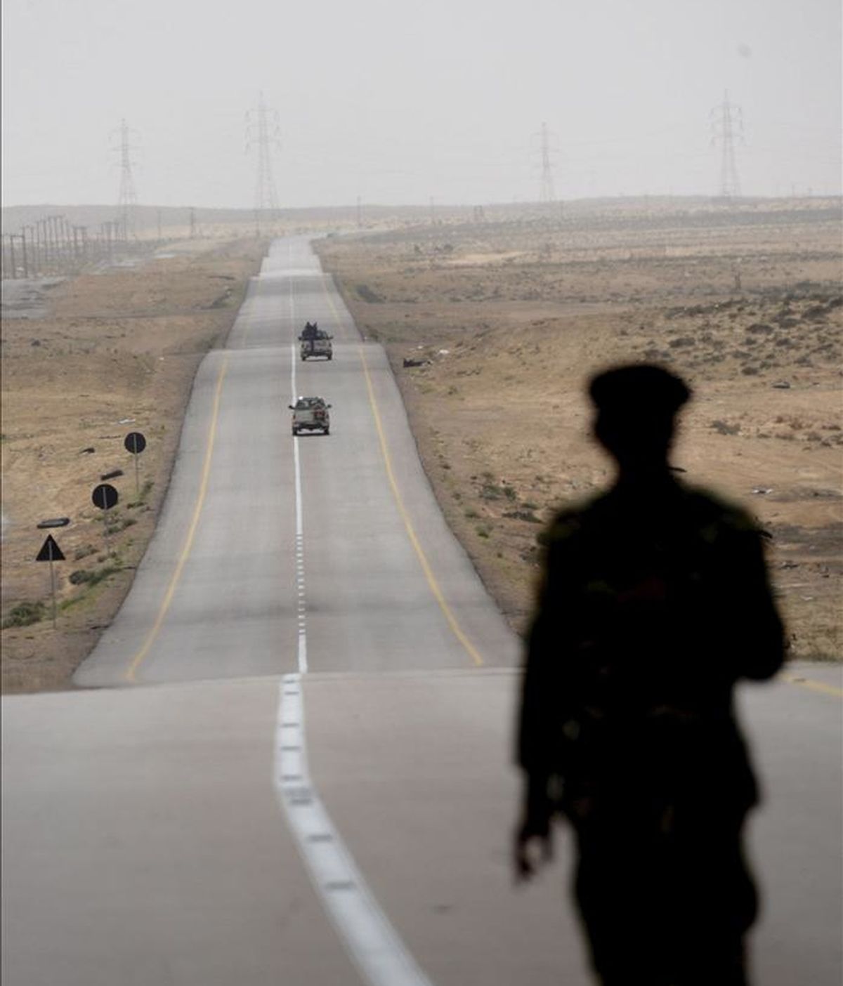 Un soldado rebelde libio observa una carretera cerca de la línea de combate entre Ajdabiya y Brega, en Libia. Los rebeldes libios que intentaban retomar el noroeste del puerto petrolero de Brega fueron replegados hacia la ciudad de Ajdabiya por las fuerzas leales a Gadafi. EFE