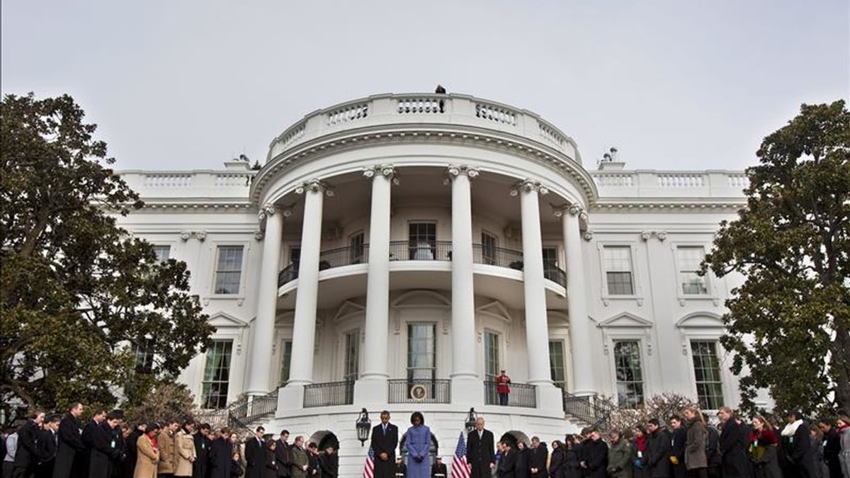 El presidente de Estados Unidos, Barack Obama, su esposa Michelle Obama (c) y empleados de la Casa Blanca guardan un minuto de silencio, en la Casa Balanca de Washington DC, para condenar el tiroteo del sábado en Tucson, Arizona. EFE