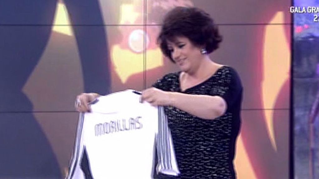 La colaboradora, aunque reacia, se enfunda la camiseta