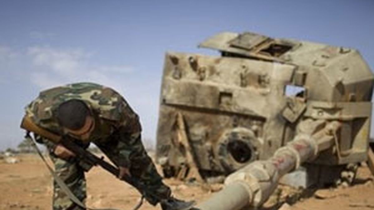Un soldado rebelde examinan un tanque destruido de las fuerzas gadafistas. Foto: AP