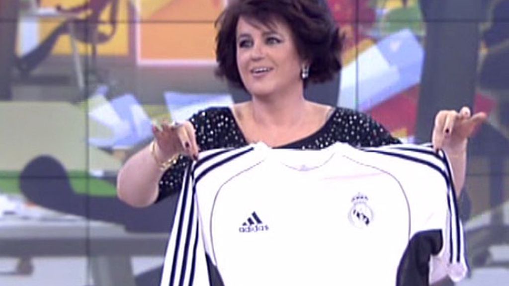 La colaboradora, aunque reacia, se enfunda la camiseta
