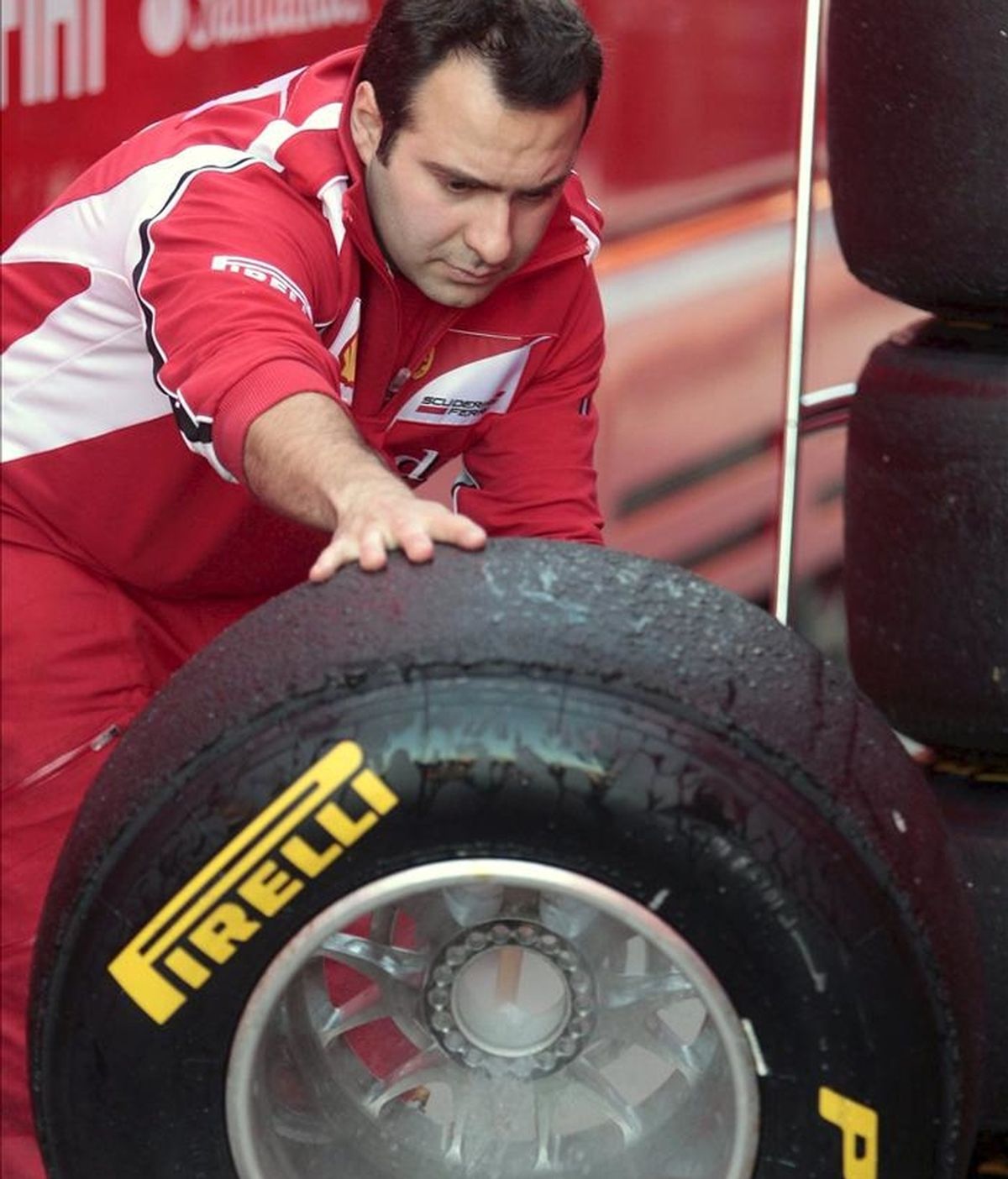 Un mecánico de Ferrari limpia un neumático de Pirelli, en el circuito Ricardo Tormo de Cheste (Valencia) en la segunda jornada de entrenamientos dentro de la pretemporada del Mundial 2011. EFE