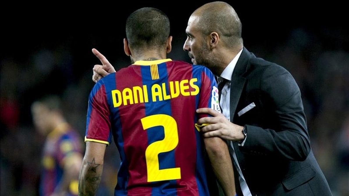El entrenador del FC Barcelona Josep Guardiola (d) da instrucciones al defensa brasileño Daniel Alves durante el partido, correspondiente a la trigésima tercera jornada del Campeonato Nacional de Liga de Primera División, que el conjunto azulgrana disputó contra el Osasuna en el Camp Nou. EFE