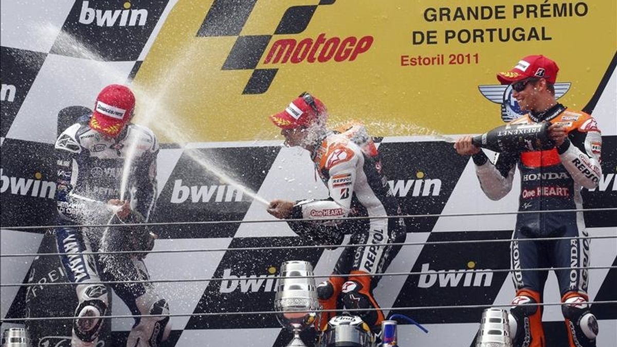 El piloto español de MotoGP de Repsol Honda, Dani Pedrosa (c), celebra en el podio la victoria conseguida en el Gran Premio de Portugal, junto al español de Yamaha, Jorge Lorenzo (izda), segundo, y al australiano de Repsol Honda, Casey Stoner, tercero, en el circuito de Estoril, ayer. EFE