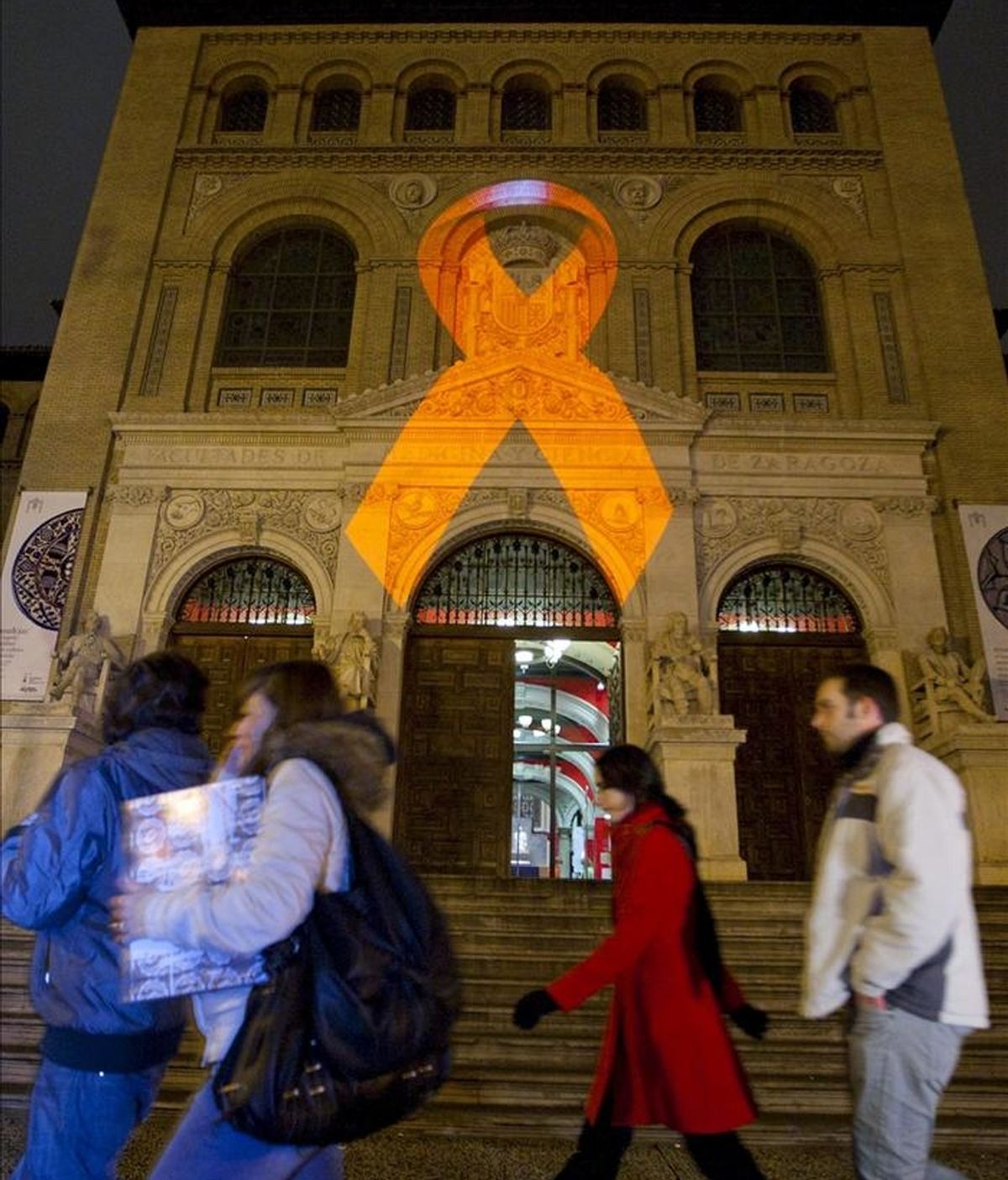 En la iamgen, el Paraninfo de la Universidad de Zaragoza iluminado con la proyección de un gran lazo rojo para recordar la importancia de respetar los derechos de las personas que viven con el VIH en España. EFE/Archivo