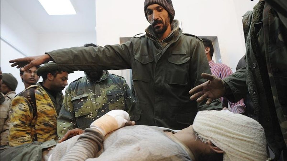 Rebeldes libios acompañan a un compañero que resultó herido en un bombardeo aéreo de la OTAN cerca de la ciudad de Brega, al este de Trípoli, en un hospital de Ajdabiya (Libia). EFE