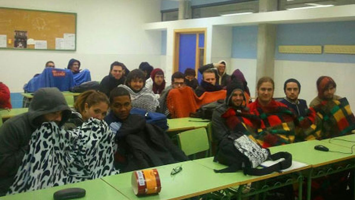 Varios alumnos en clase con mantas para evitar el frío
