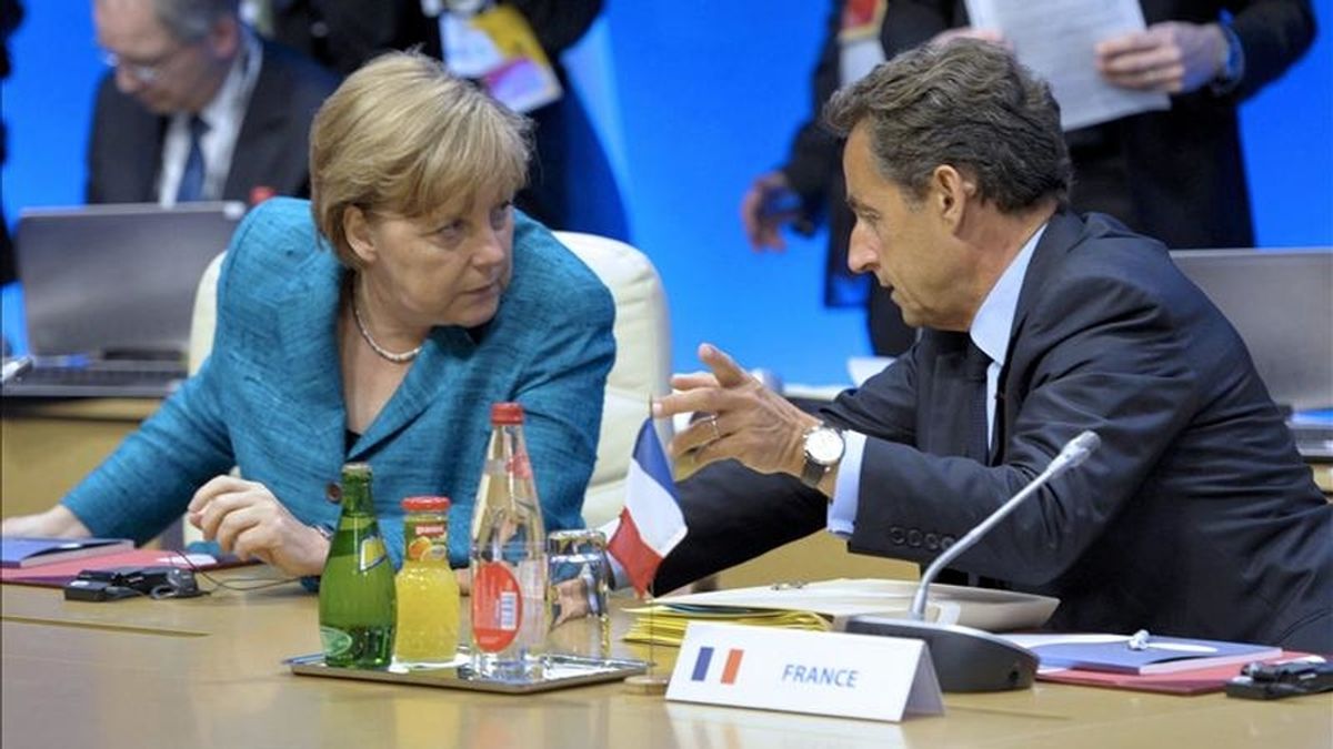 El presidente francés, Nicolas Sarkozy, (d), conversa con la canciller alemana Angela Merkel durante la Cumbre del G8, en Deauville (Francia), hoy, jueves 26 de mayo de 2011. Los dirigentes de los países del G8 comenzaron hoy su cumbre de dos días en la localidad francesa de Deauville (noroeste), en la que su objetivo principal es apoyar las reformas en los países árabes. EFE