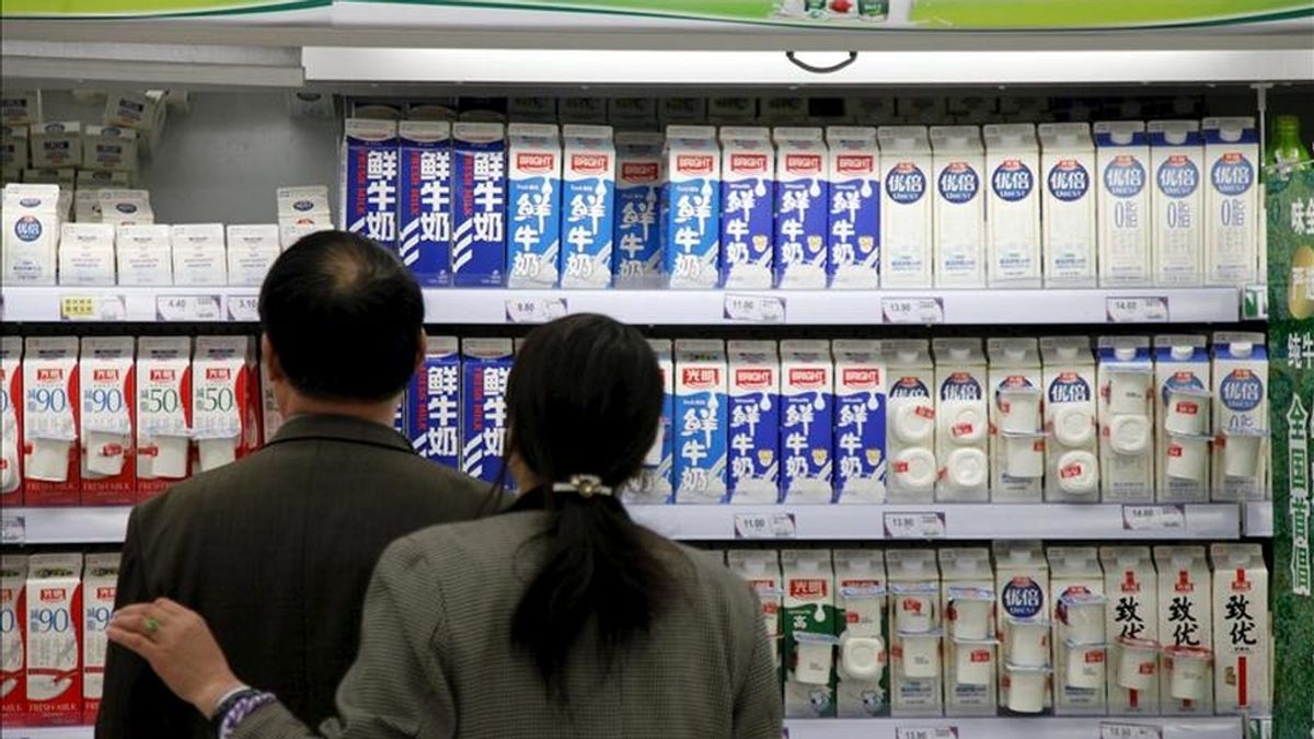 Una pareja mira envases de cartón de leche fresca en un supermercado de Shanghai, China. EFE/Archivo