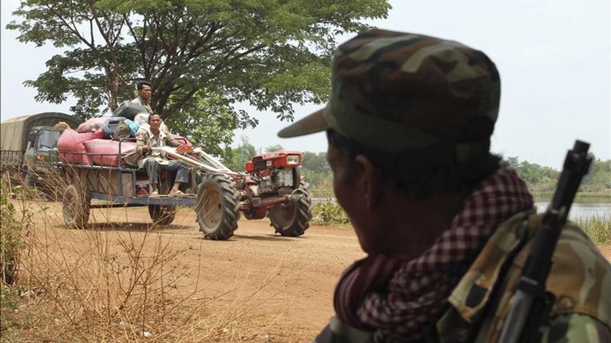 Un soldado camboyano observa ayer a varios civiles camboyanos que a bordo de un tractor se dirigen a lugar seguro tras abandonar su hogar para huir del conflicto en Banteay Ampil (Camboya). EFE