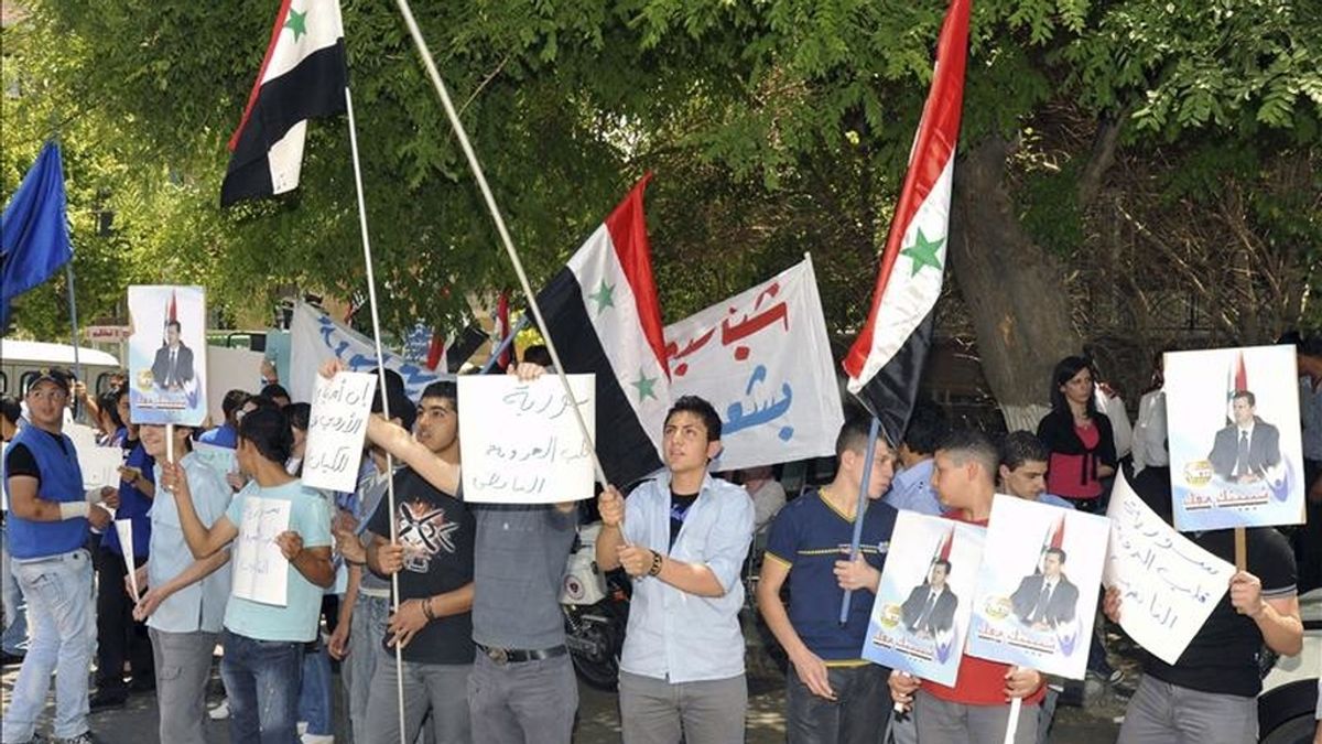 Fotografía cedida por la agencia oficial de noticias siria, SANA, que muestra a un grupo de ciudadanos sirios protestando contra las sanciones impuestas por la Unión Europea (UE) al presidente de su país, Bachar al Asad, frente a la oficina de la UE en Damasco. EFE/Archivo