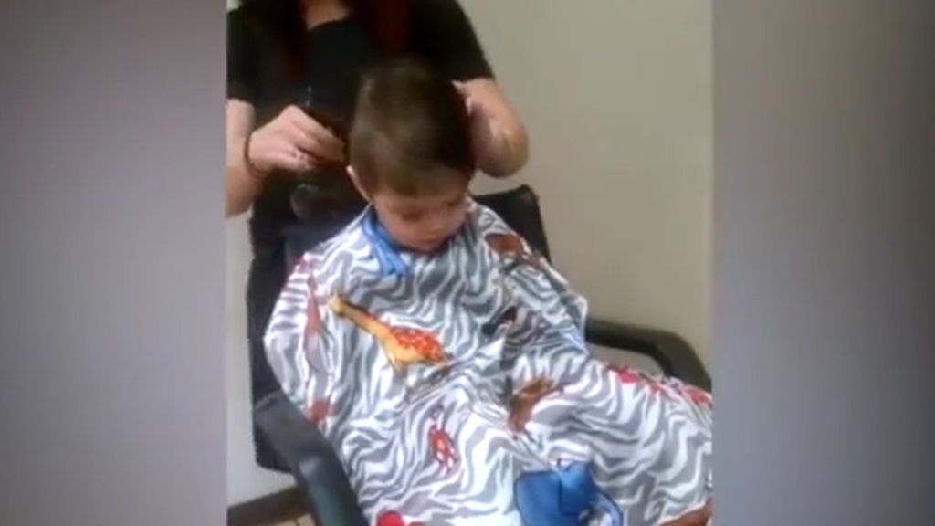 Un niño lucha por mantenerse despierto en su primer corte de pelo