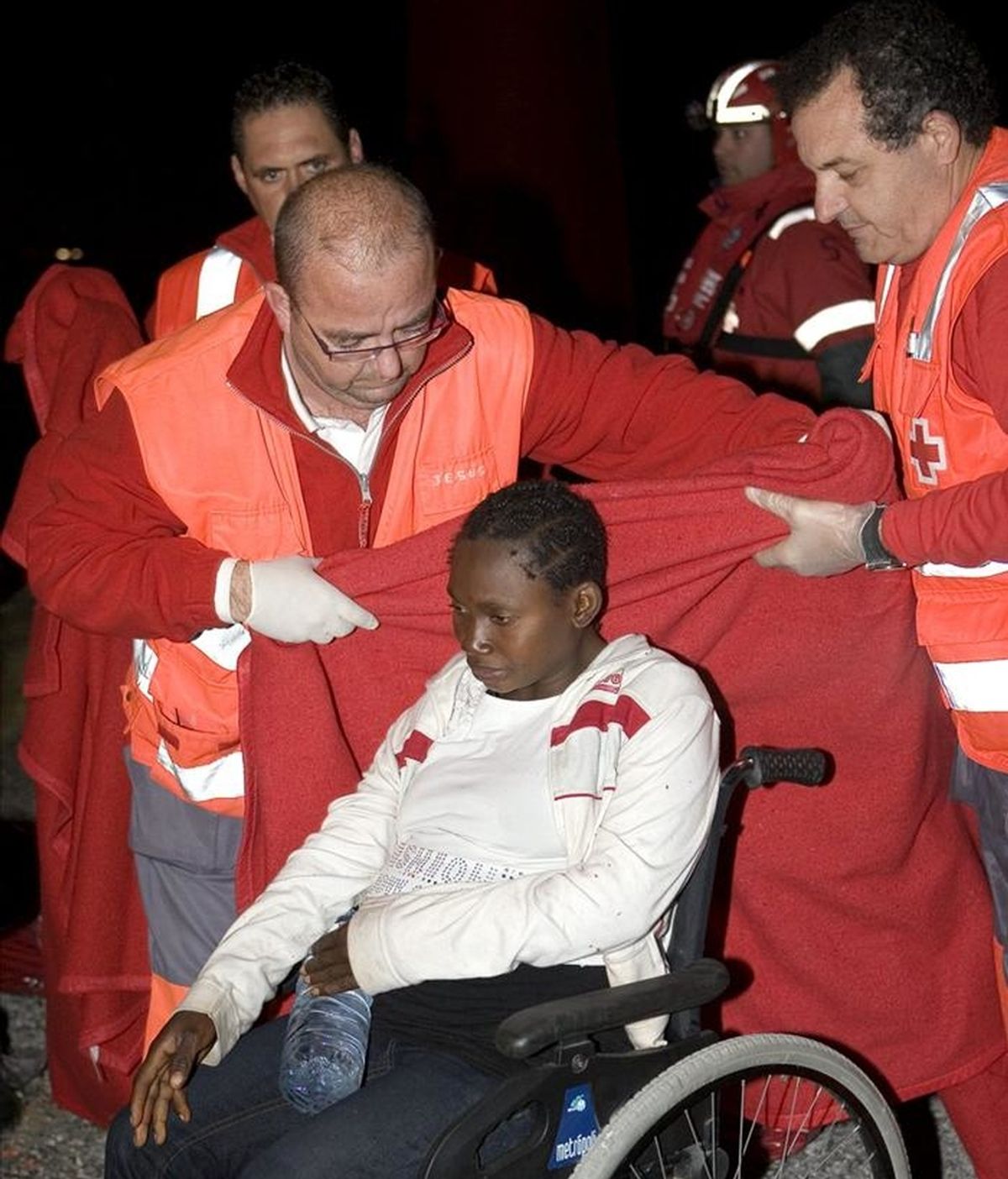 Miembros de Cruz Roja socorren a una mujer embarazada que llegó en febreroal puerto de Motril junto a otras 54 o 55 personas de origen subsahariano, entre ellos seis niños. EFE/Archivo