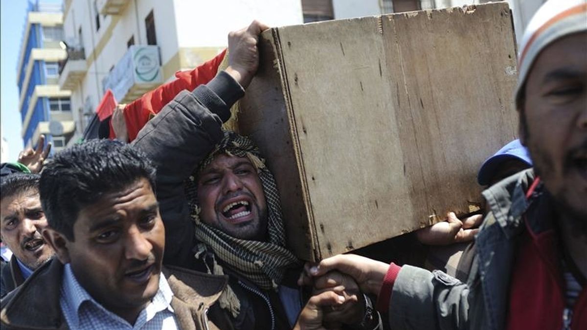 Libios sostienen el ataúd de un soldado rebelde que, según los rebeldes, murió en combate, durante los rezos del viernes en Bengasi, Libia. EFE