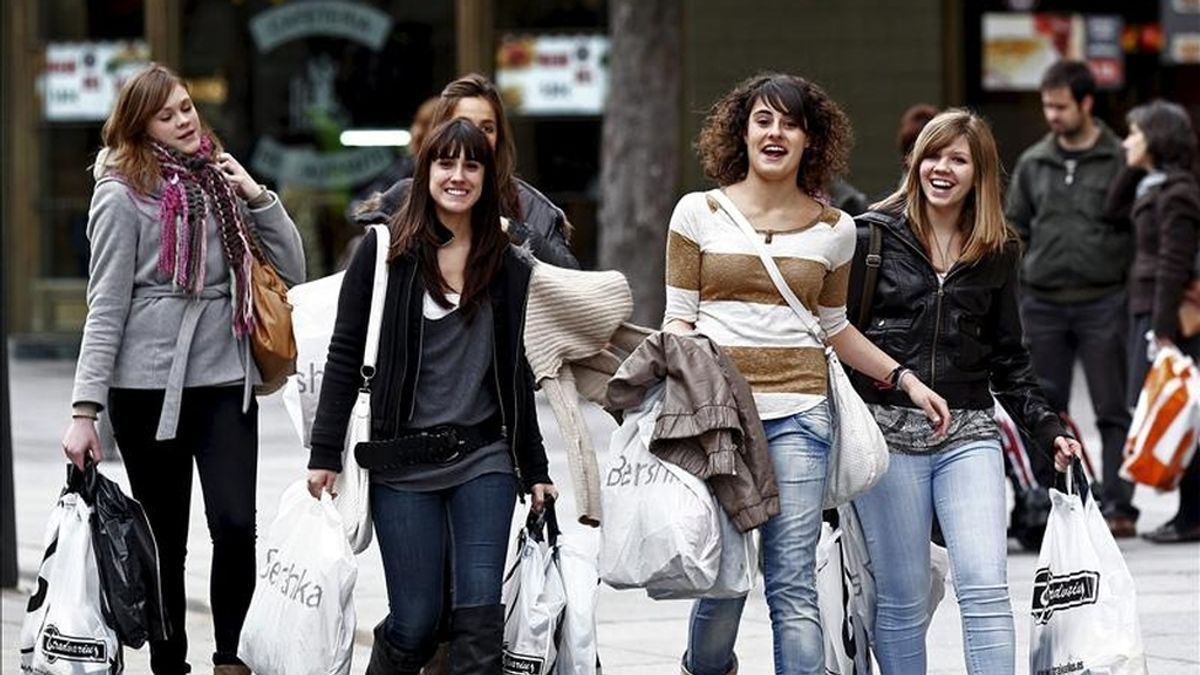 Un grupo de jóvenes camina con sus compras por la calle. EFE/Archivo