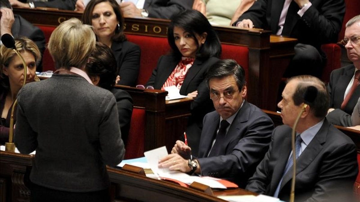 El primer ministro francés, François Fillon, (2d), conversa con la ministra de Exteriores, Michele Alliot-Marie, (i), durante una sesión plenaria en el parlamento francés, en París, Francia. EFE