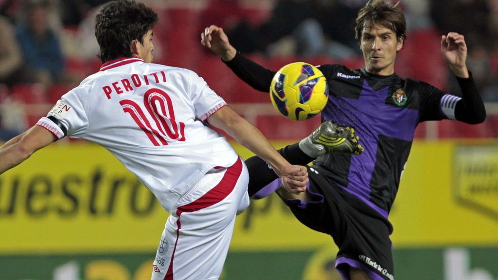 El centrocampista argentino del Sevilla CF, Diego Perotti (i), lucha el balón con Álvaro Rubio, centrocampista del Valladolid