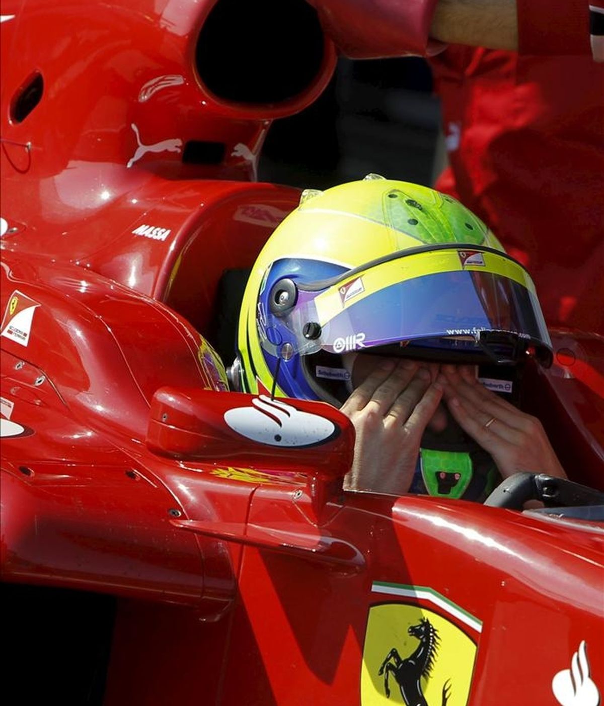 El piloto brasileño Felipe Massa, de la escudería Ferrari, se seca el sudor, durante los entrenamientos de pretemporada de Fórmula Uno que comenzaron hoy en el circuito de Jerez, en el que participan once escuderías. EFE