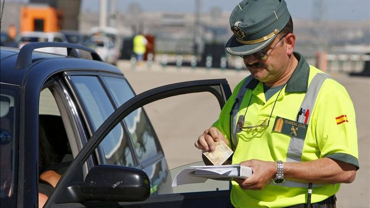 un agente de la Guardia Civil cobrando una multa a un vehículo en la R-3. EFE/Archivo